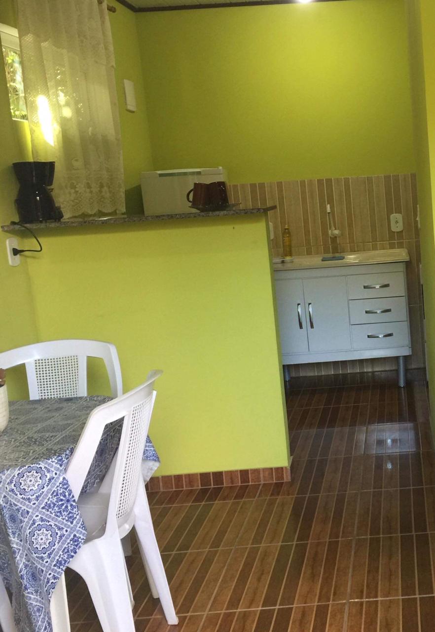 Cozinha com geladeira, fogão, cafeteira e sanduicheira.